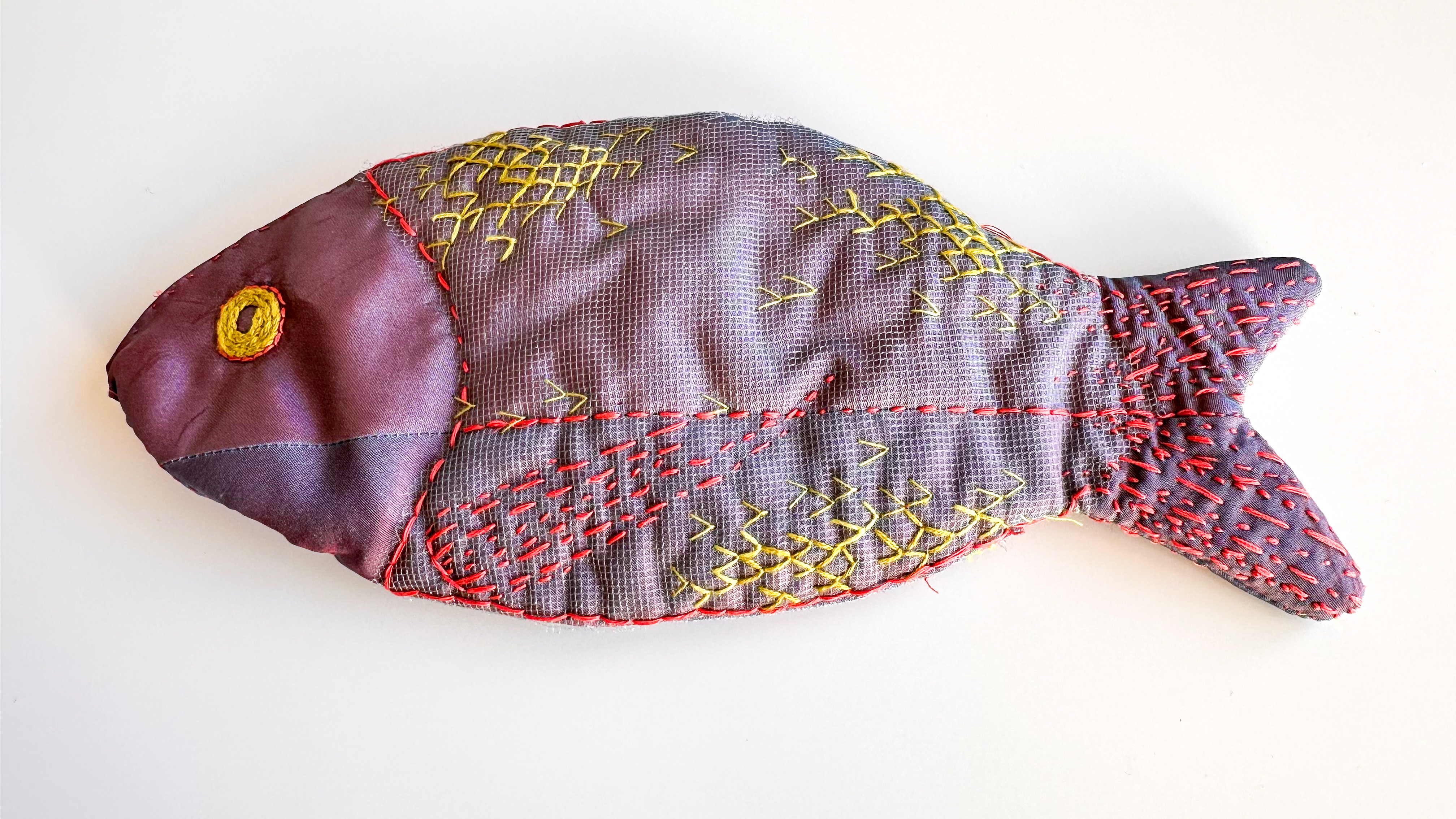 Purse, fish form, in batik dyed fabric, acrylic fish bone lining, exterior embroidered.